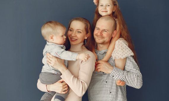 A joyful family portrait showcasing parents and their two children, expressing love and togetherness.